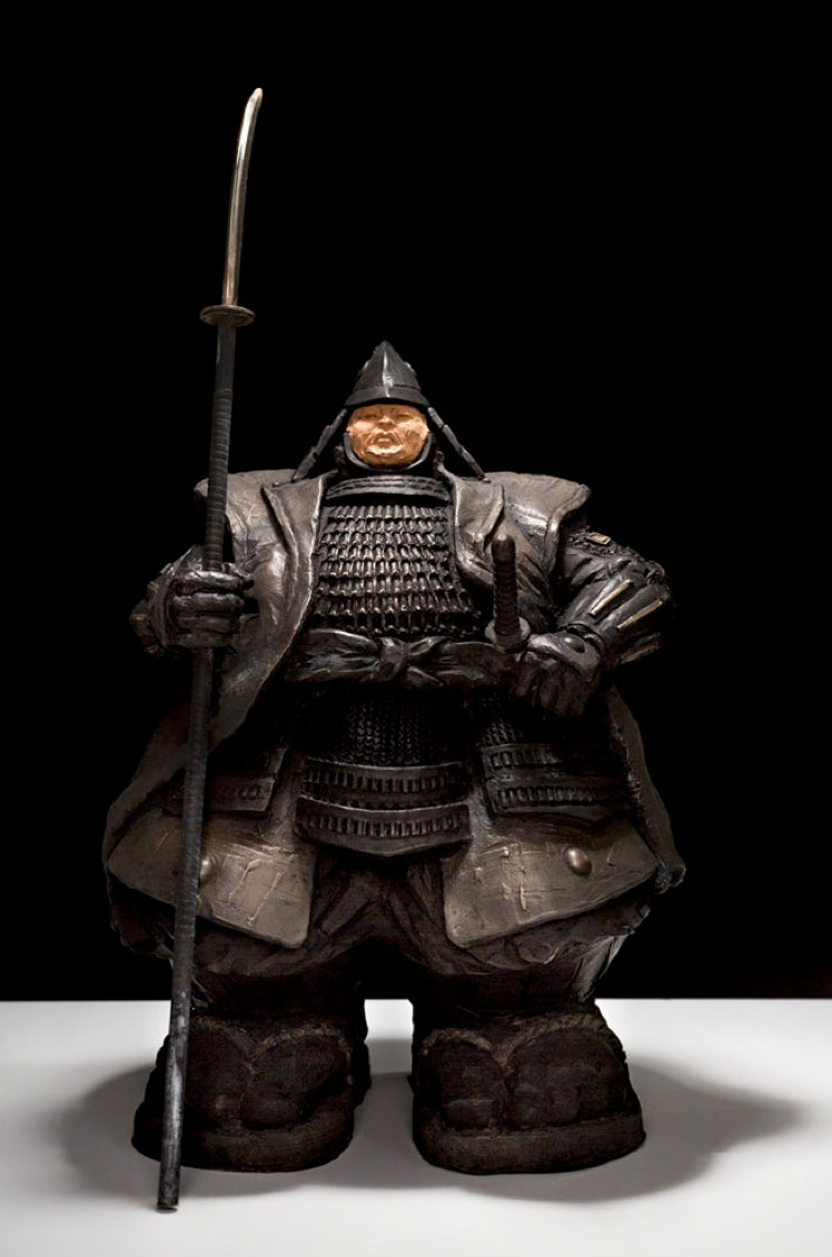 “Custode Samurai” di Matteo Pugliese è una scultura in bronzo che rappresenta un guerriero frontale e compatto, simbolo di protezione e forza interiore. La ricchezza dell’armatura e la solidità dei volumi ne rafforzano la presenza monumentale. L’opera riflette sui temi della vigilanza e della responsabilità, ed è esposta alla Galleria PUNTO SULL'ARTE, Varese, Italia.